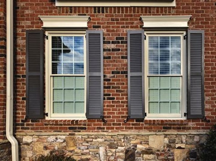 How do you hang wood shutters on brick house?
