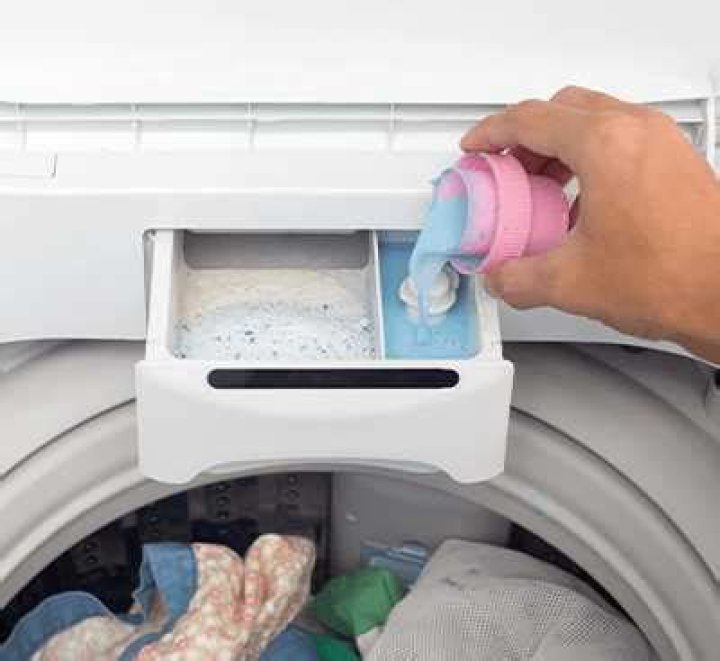 How do you unclog a fabric softener dispenser in a washing machine?